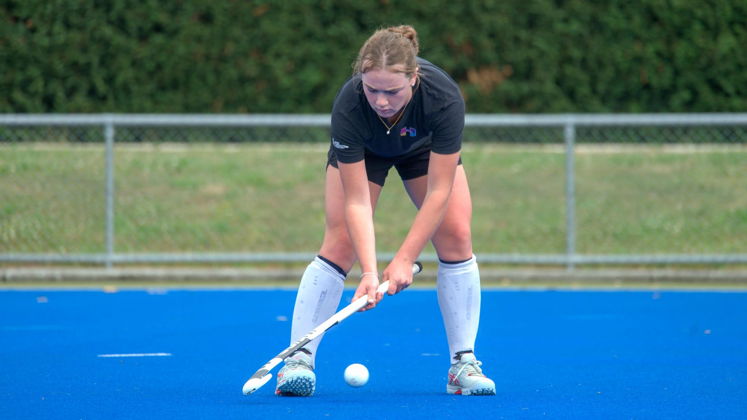An Inside Hockey player practising ball control on blue turf.